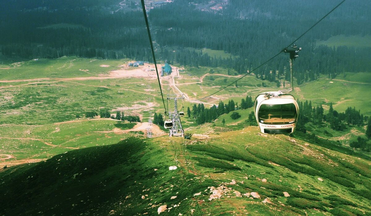 Gulmarg meadow with Gondola cable car and snow capped Himalayan peaks in Kashmir