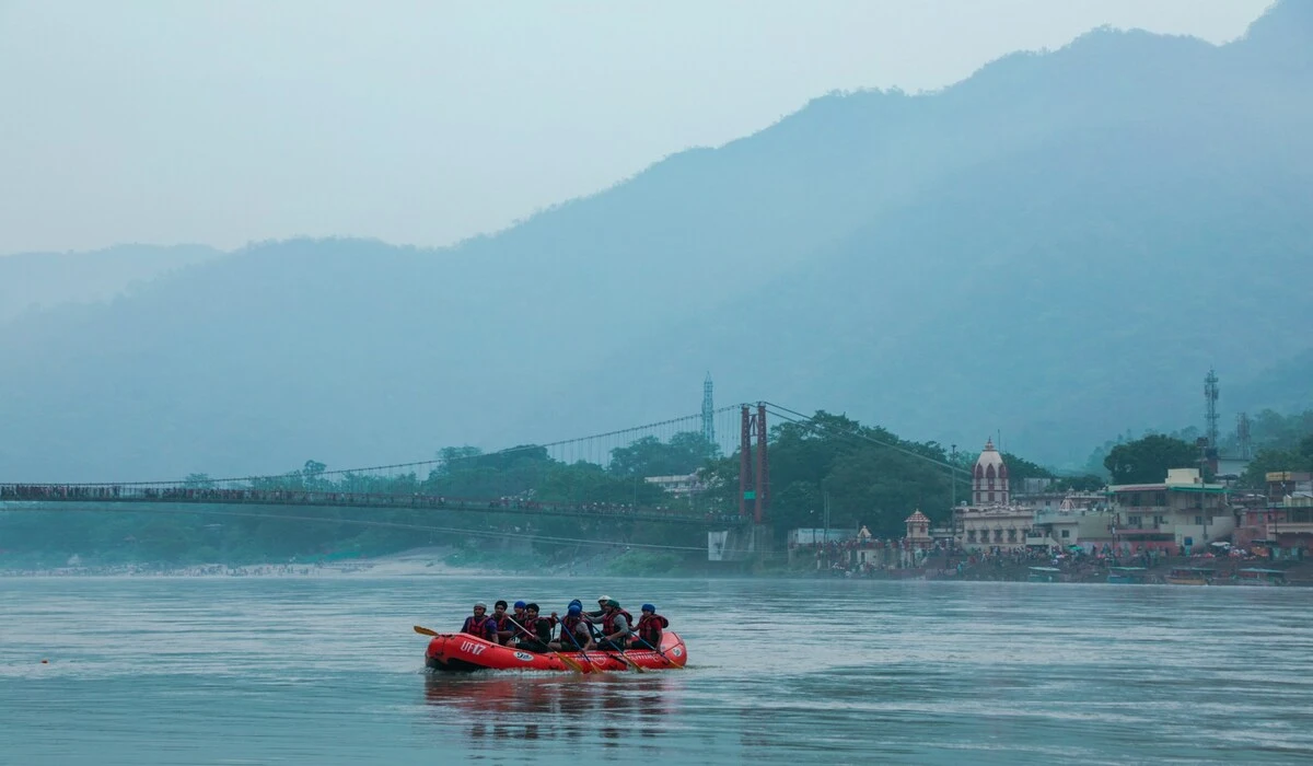 Suspension bridge over Ganges River in Rishikesh with Himalayan foothills under clear winter skies